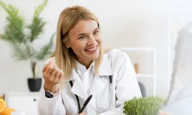 南达科塔州 family nurse practitioner smiling with pediatric patient during appointment